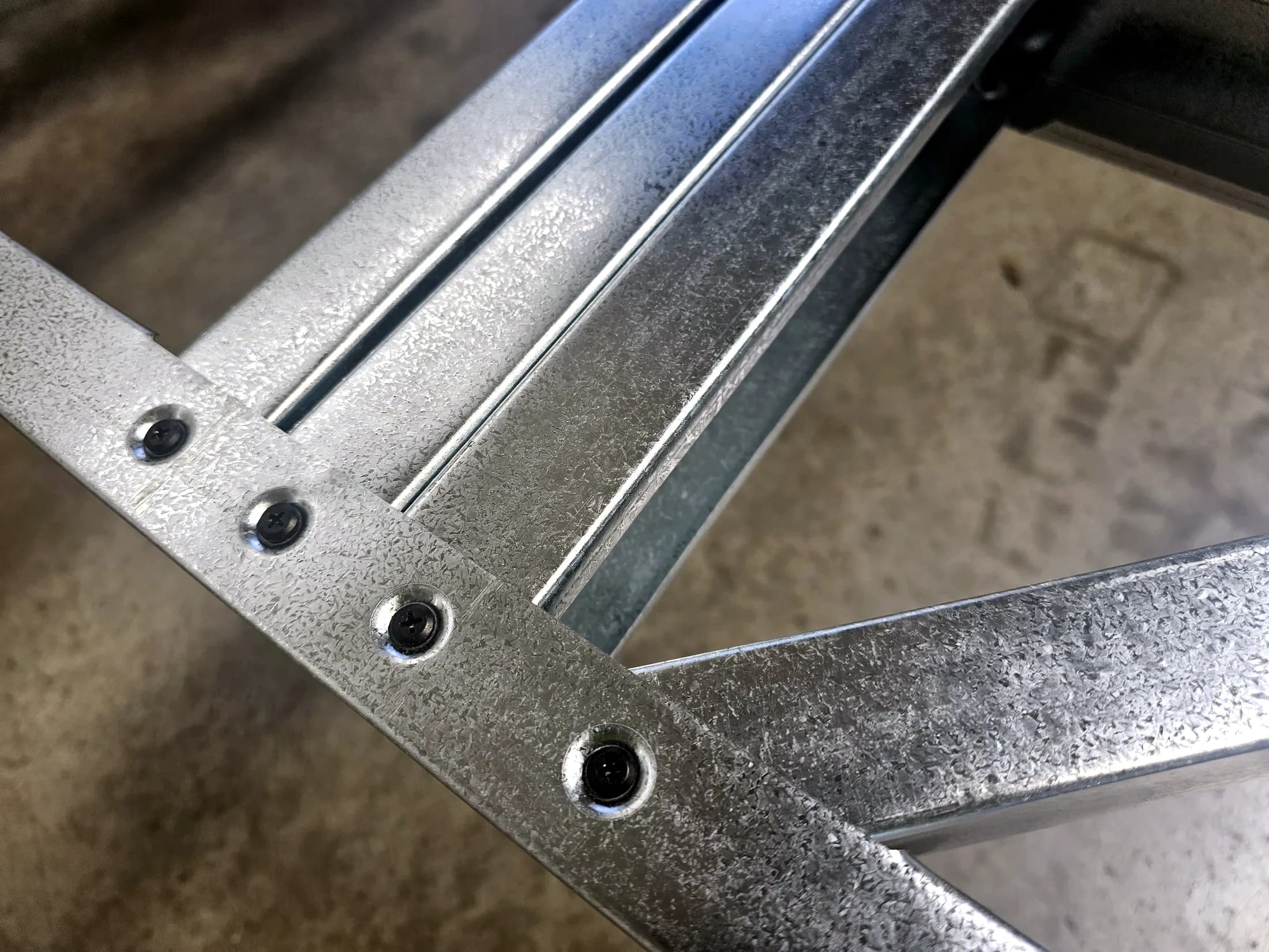 Close-up of screw fixings along a galvanised steel framing section